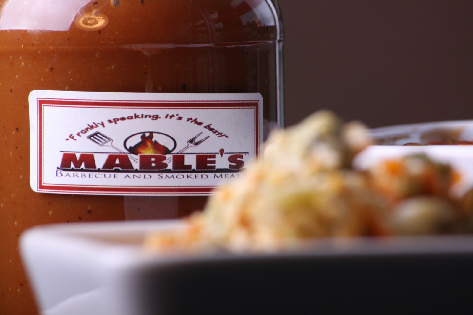 Mable's barbecue sauce beside a bowl of slaw